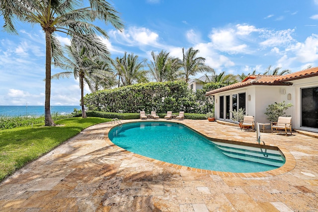 pool with a water view and a patio