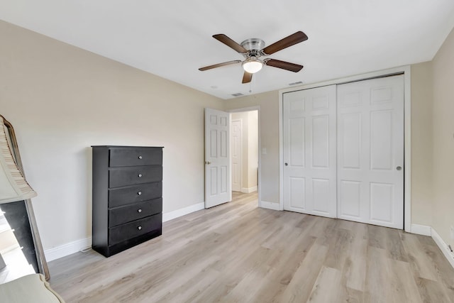 unfurnished bedroom featuring light hardwood / wood-style floors, ceiling fan, and a closet