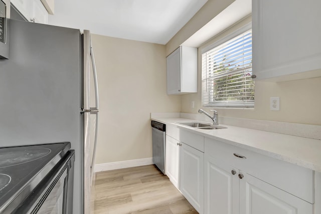 kitchen featuring light hardwood / wood-style flooring, white cabinetry, appliances with stainless steel finishes, and sink