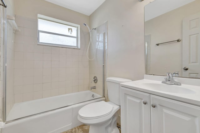 full bathroom featuring tiled shower / bath, vanity, and toilet