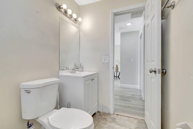 bathroom with vanity, toilet, and hardwood / wood-style flooring