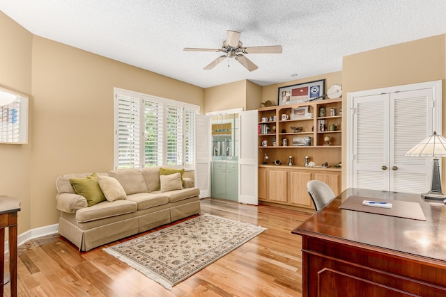 office space featuring ceiling fan, wood-type flooring, and a textured ceiling