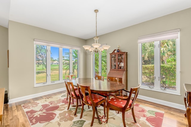 dining space with a wealth of natural light, a chandelier, and light hardwood / wood-style floors