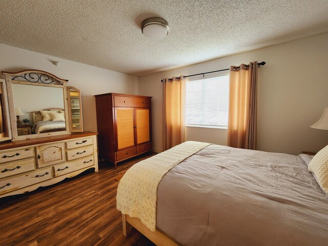 bedroom featuring dark wood-type flooring and a textured ceiling