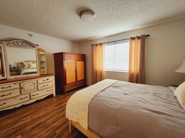 bedroom featuring a textured ceiling and dark wood finished floors