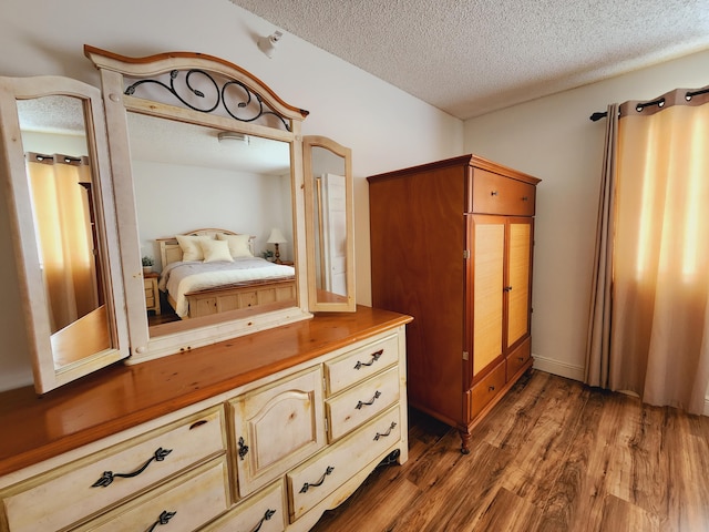 bedroom featuring dark wood-type flooring and a textured ceiling