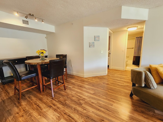 dining room featuring a textured ceiling and hardwood / wood-style floors