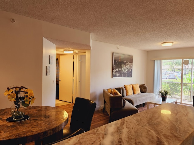 living area with a textured ceiling and wood finished floors