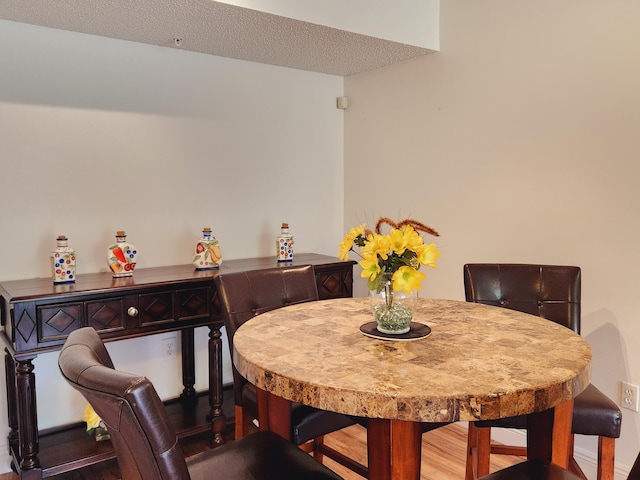 dining area featuring dark hardwood / wood-style flooring and a textured ceiling