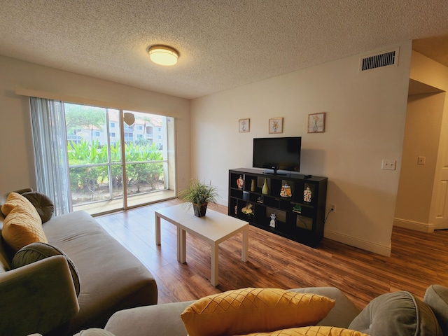 living room with hardwood / wood-style floors and a textured ceiling