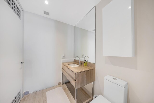 bathroom featuring vanity, toilet, and hardwood / wood-style floors