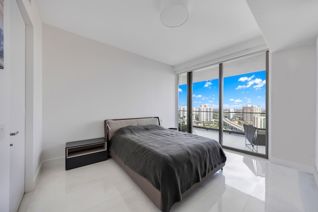 bedroom with a wall of windows and access to exterior