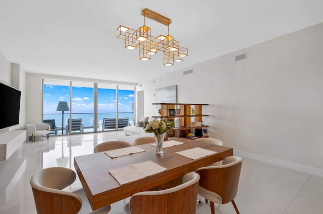 tiled dining space featuring a wall of windows, a chandelier, and a water view