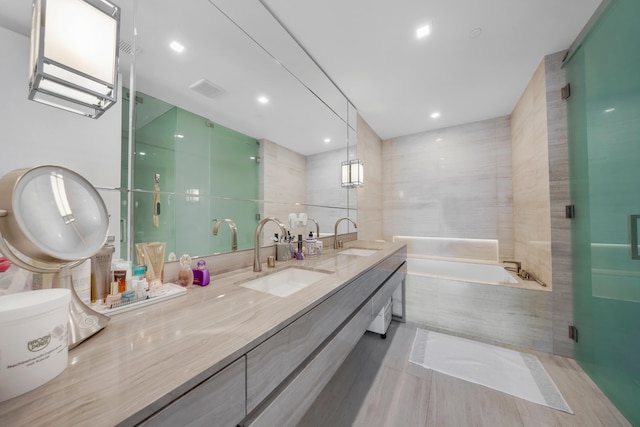 bathroom with vanity, plus walk in shower, and tile walls