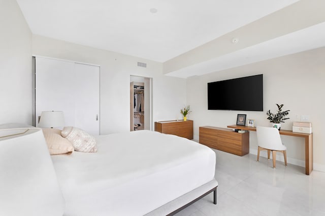 bedroom with a walk in closet, a closet, and light tile patterned floors