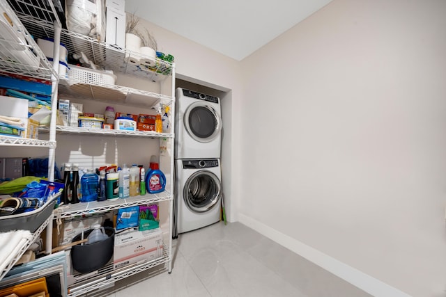 clothes washing area featuring stacked washer and dryer