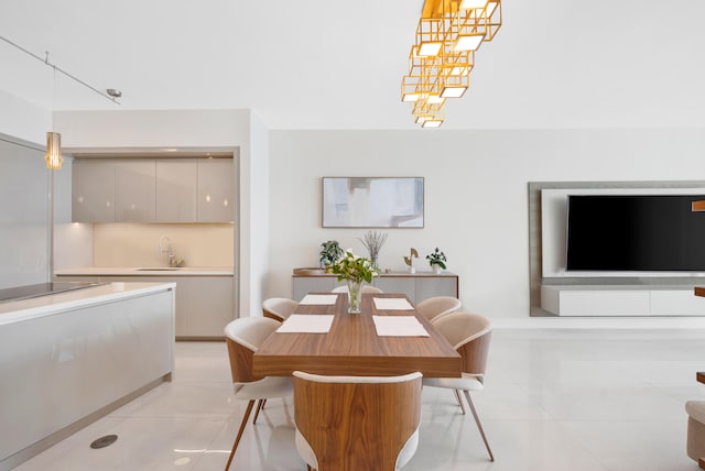 tiled dining space featuring sink and a notable chandelier