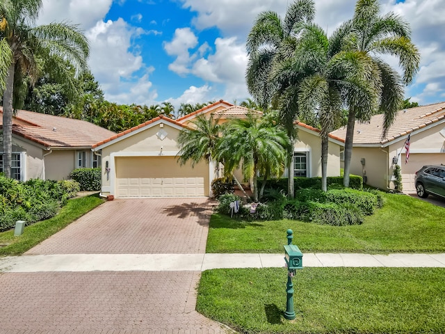 mediterranean / spanish-style home with a garage and a front yard