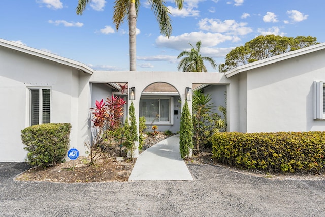 entrance to property featuring stucco siding