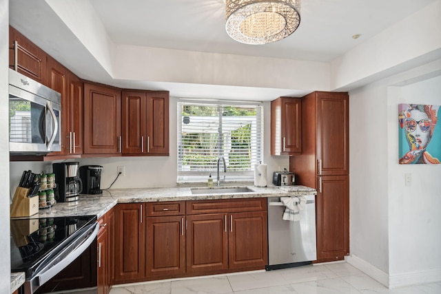 kitchen with baseboards, light stone countertops, appliances with stainless steel finishes, marble finish floor, and a sink