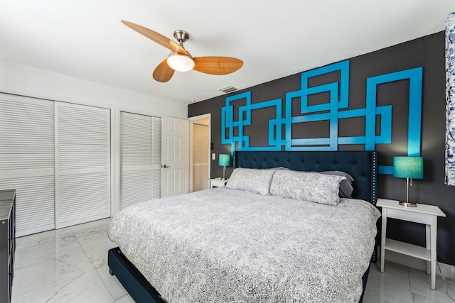 bedroom with a ceiling fan, visible vents, and multiple closets