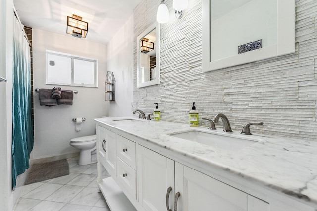 bathroom featuring double vanity, decorative backsplash, toilet, and a sink