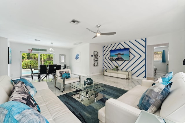 living area featuring baseboards, visible vents, marble finish floor, and ceiling fan