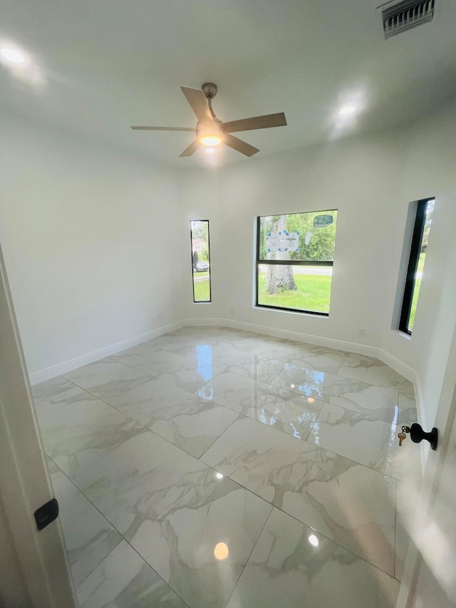 tiled spare room with ceiling fan