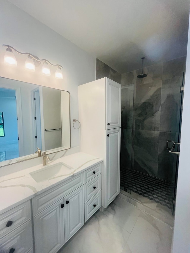 bathroom with a shower with shower door, vanity, and tile patterned floors