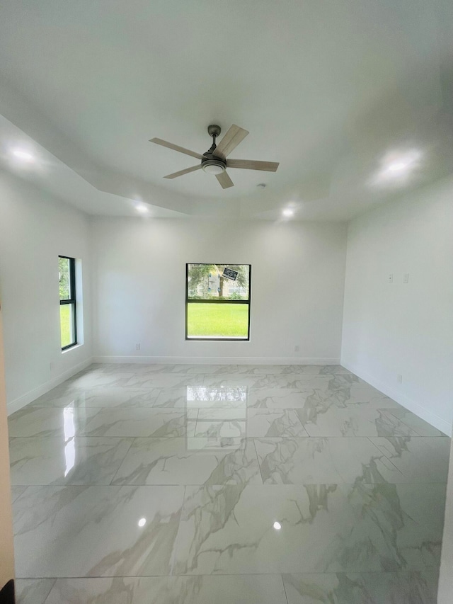 spare room with light tile patterned floors and ceiling fan