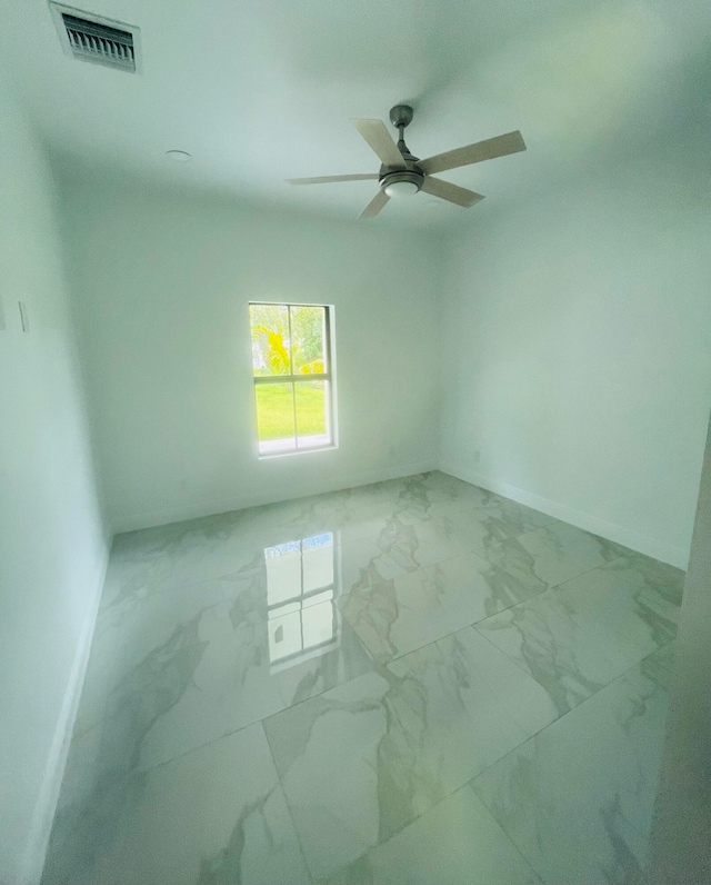 tiled spare room featuring ceiling fan