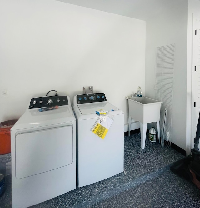 clothes washing area with separate washer and dryer and sink