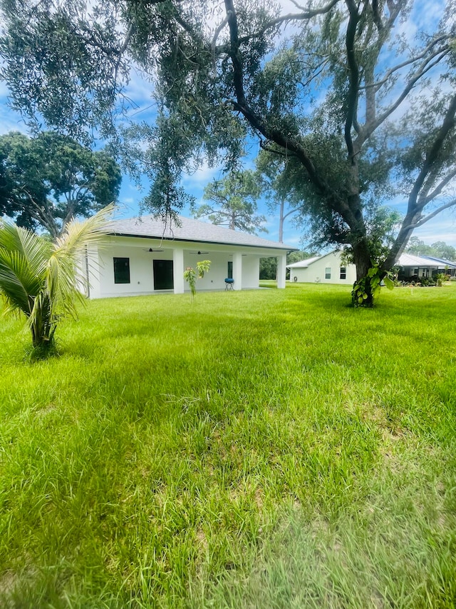 rear view of property featuring a lawn