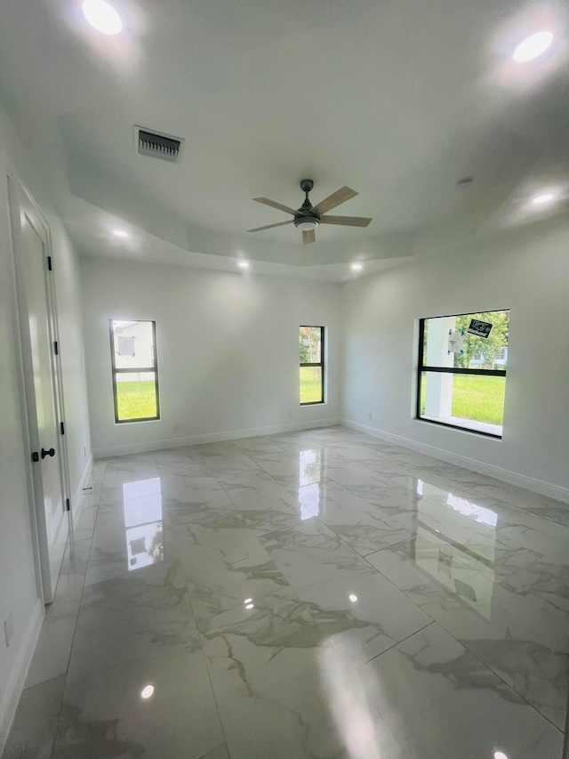 spare room with a healthy amount of sunlight, tile patterned flooring, and ceiling fan