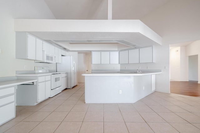 kitchen featuring white cabinetry, white appliances, kitchen peninsula, and light tile patterned floors