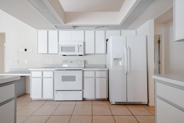 kitchen featuring light tile patterned floors, white appliances, and white cabinetry