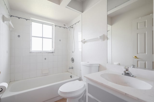 full bathroom with toilet, tiled shower / bath combo, and vanity