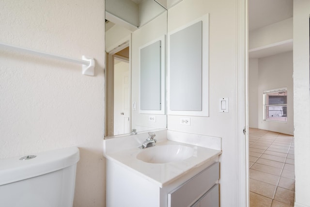 bathroom with vanity, toilet, and tile patterned floors