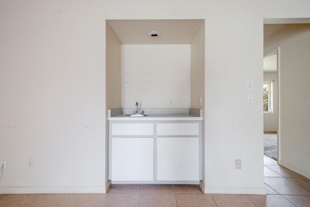 bar featuring light tile patterned floors and sink