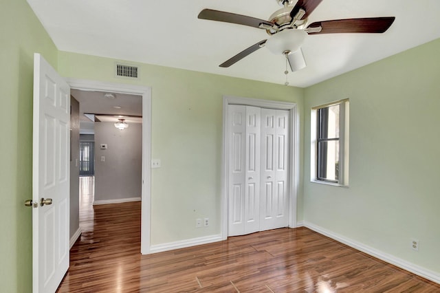 unfurnished bedroom featuring hardwood / wood-style flooring, a closet, and ceiling fan