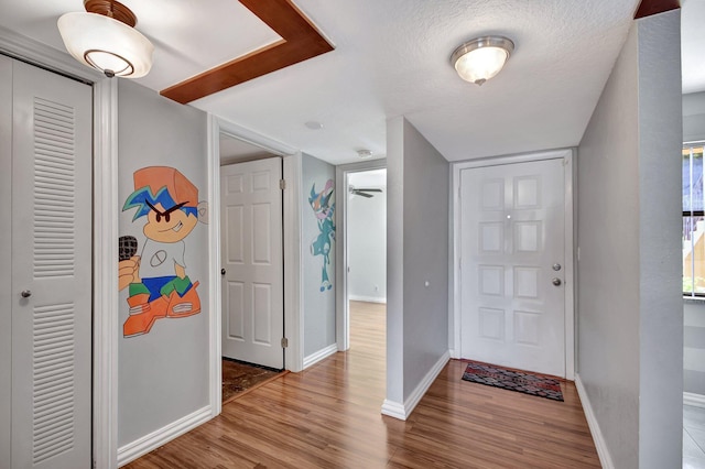 entrance foyer with a textured ceiling and light hardwood / wood-style flooring