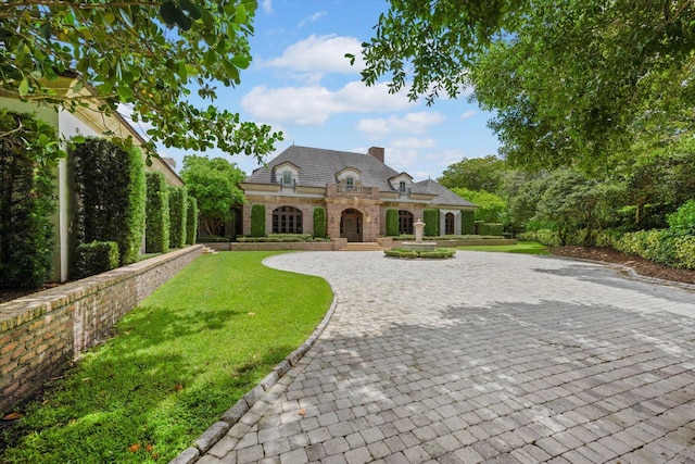 french provincial home with a front lawn