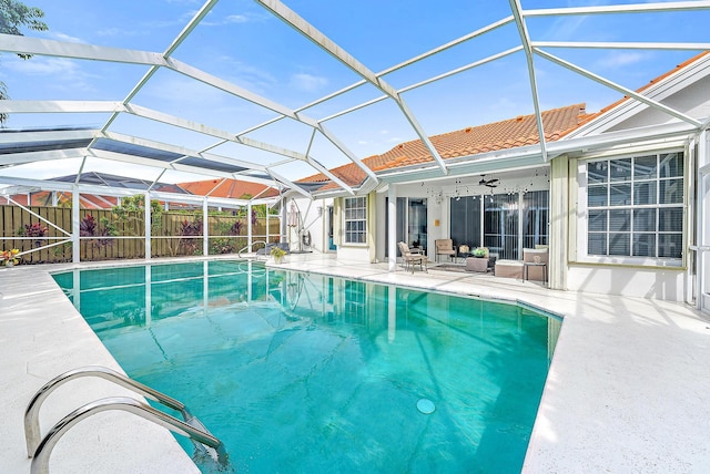 view of swimming pool with ceiling fan, a patio area, and a lanai