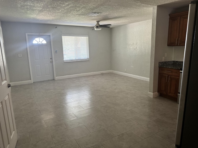 foyer entrance featuring ceiling fan, a textured ceiling, and light tile patterned floors