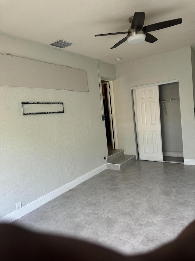 unfurnished bedroom with ceiling fan and a closet