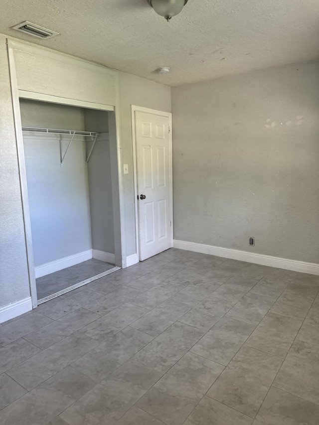 unfurnished bedroom featuring a closet and a textured ceiling