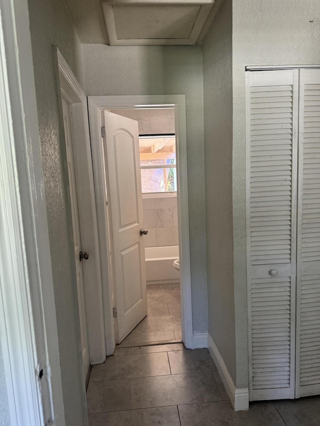 hall with tile patterned floors