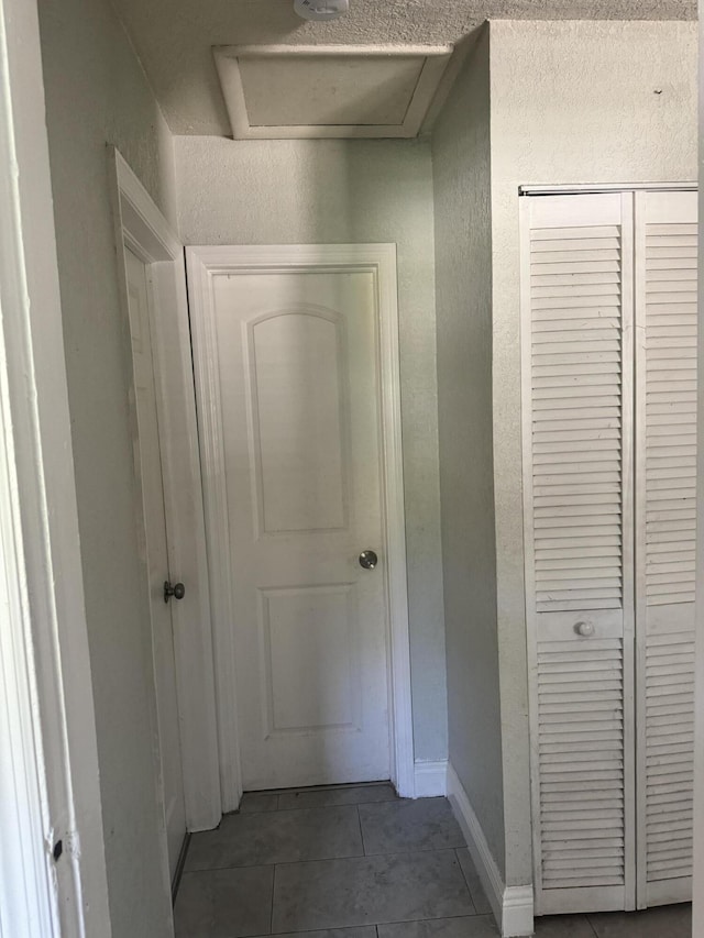 hall featuring dark tile patterned floors