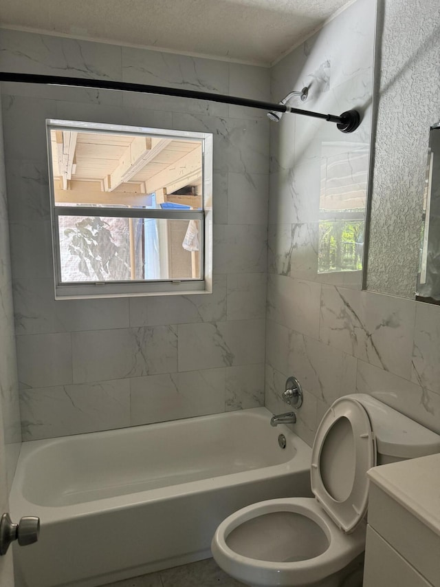 full bathroom featuring tile walls, vanity, a textured ceiling, tiled shower / bath combo, and toilet