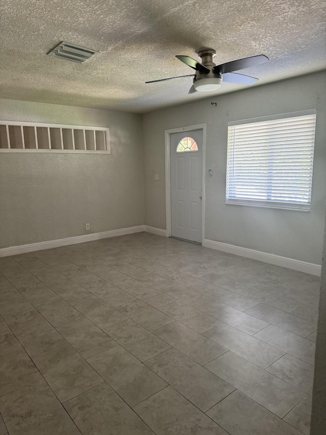 foyer featuring ceiling fan, a textured ceiling, and tile patterned flooring